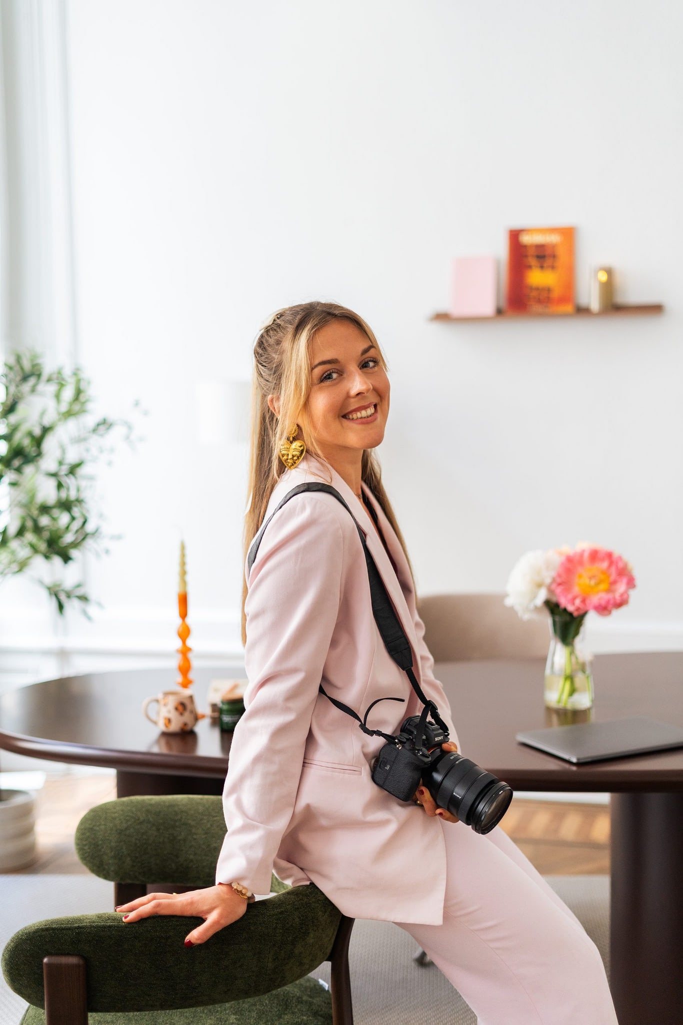 photo de Meije souriante, tenant son appareil photo dans un intérieur lumineux